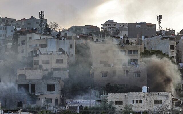 De la fumée s'élève des bâtiments après un raid israélien dans la ville de Jénine en Cisjordanie, le 7 mars 2023. (Crédit : Jaafar Ashtiyeh/AFP)