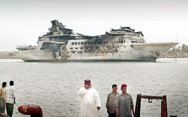 Cette photo prise le 10 avril 2003 montre des enfants irakiens devant le luxueux yacht du dictateur Saddam Hussein, le Al-Mansur, amarré à Bassorah après avoir été bombardé lors de l'invasion de l'Irak par les États-Unis, qui a mis fin à des décennies de règne sans partage de Saddam Hussein. Mesurant 120 mètres de long et pesant plus de 7 000 tonnes, l'ancien yacht présidentiel avait été assemblé en Finlande et livré à l'Irak en 1983, selon le site web du designer danois Knud E. Hansen. (Crédit : SIMON WALKER / POOL / AFP)