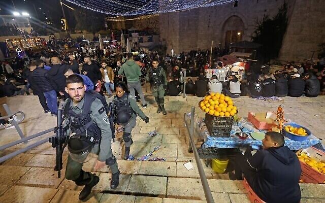 Les forces de l'ordre israéliennes patrouillent alors que les Palestiniens se rassemblent devant la porte de Damas, dans la Vieille Ville de Jérusalem, le 22 mars 2023, avant le mois de jeûne musulman du Ramadan. (Crédit : Ahmad Gharabli/AFP)