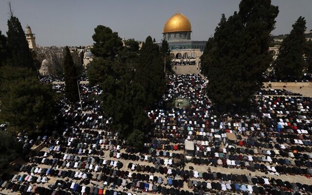 Des personnes accomplissent la première prière du vendredi midi du mois de jeûne islamique du Ramadan, devant le Dôme du Rocher dans l'enceinte de la mosquée Al-Aqsa à Jérusalem, le 24 mars 2023. (Crédit : AHMAD GHARABLI / AFP)