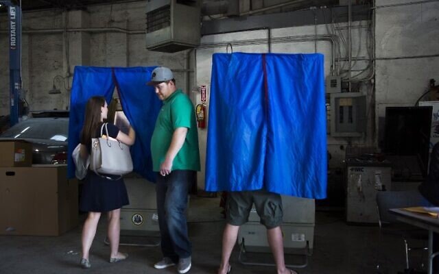 Des résidents locaux déposant leurs bulletins de vote le jour des primaires, alors que le vote primaire a lieu en Pennsylvanie, au Maryland, au Delaware, au Rhode Island et dans le Connecticut, à Philadelphie, le 26 avril 2016. (Crédit : Jessica Kourkounis/Getty Images/AFP)