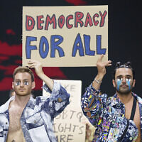 Les mannequins du créateur de mode David Weksler avec un affiche proclamant « La démocracie pour tous » sur le podium de la Kornit Fashion Week de Tel Aviv, le 19 mars 2023 (Crédit : Autorisation/Haydon Perrior)