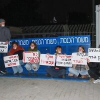 Des manifestants contre la réforme judiciaire s'attachent à la porte d'entrée de la Knesset à Jérusalem, le 30 mars 2023. (Crédit : Blocking the Coup)