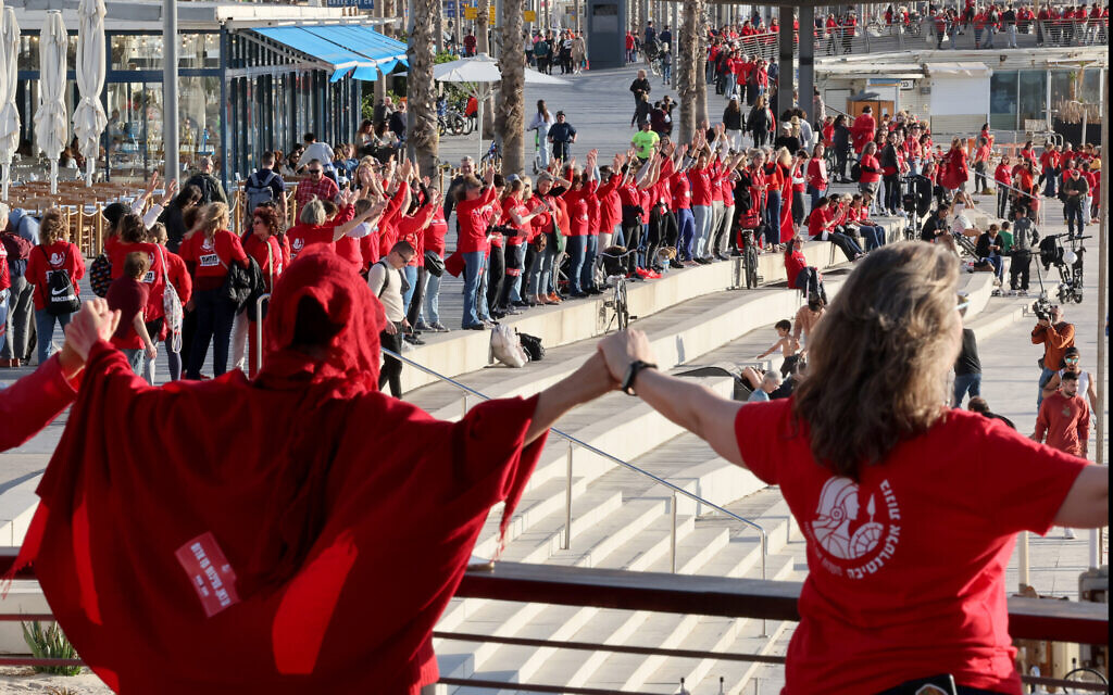 Des centaines de femmes vêtues de rouge marquent la Journée internationale de la femme et manifestent contre la refonte judiciaire prévue par le gouvernement israélien, sur la plage de Tel Aviv, le 8 mars 2023. (Crédit : JACK GUEZ / AFP)