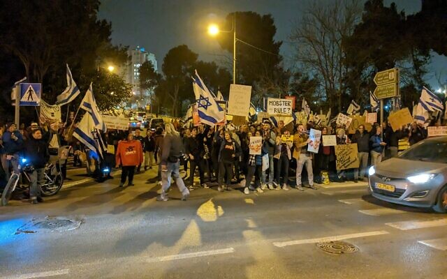 Des Israéliens protestent devant un hôtel de Jérusalem où une délégation de l'AIPAC rencontre le Premier ministre Benjamin Netanyahu le 13 mars 2023 (Crédit : Nadav Galon)