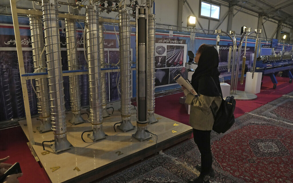 Une étudiante regarde les centrifugeuses construites dans le pays lors d'une exposition sur les avancées nucléaires de l'Iran à Téhéran, le 8 février 2023. (Crédit :  AP Photo/Vahid Salemi)