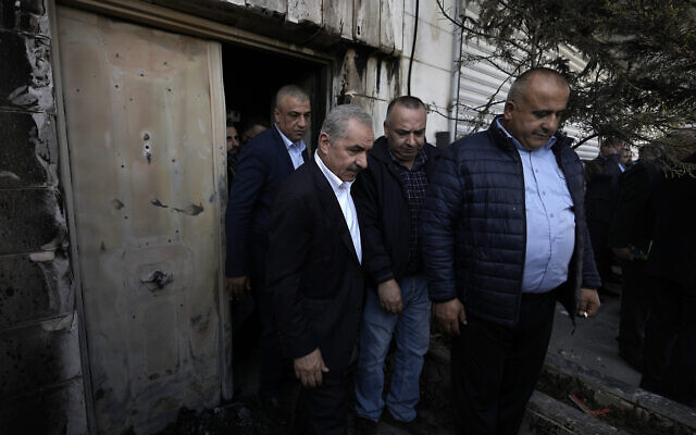Le Premier ministre de l'Autorité palestinienne, Mohammad Shtayyeh, à gauche, visitant un appartement endommagé par des véhicules incendiés lors d'une attaque de résidents d’implantations dans la ville de Huwara, en Cisjordanie, le 1er mars 2023. (Crédit : AP/Majdi Mohammed)