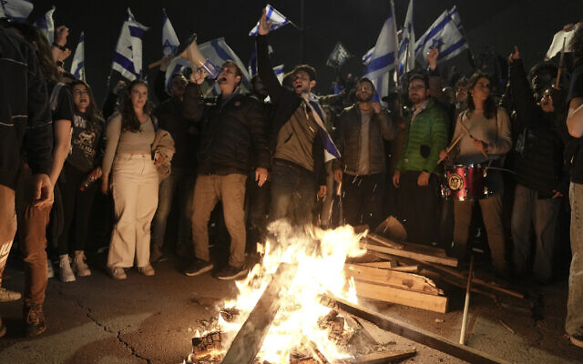 Les Israéliens opposés à la réforme judiciaire du Premier ministre Benjamin Netanyahu devant la Knesset après le renvoi du ministre de la Défense par le Premier ministre, à Jérusalem, le 27 mars 2023. (Crédit : AP Photo/ Mahmoud Illean)