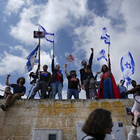 Des Israéliens protestant contre le plan de réforme du système judiciaire du Premier ministre Benjamin Netanyahu devant le Parlement, à Jérusalem, le 27 mars 2023. (Crédit : AP Photo/Ariel Schalit)