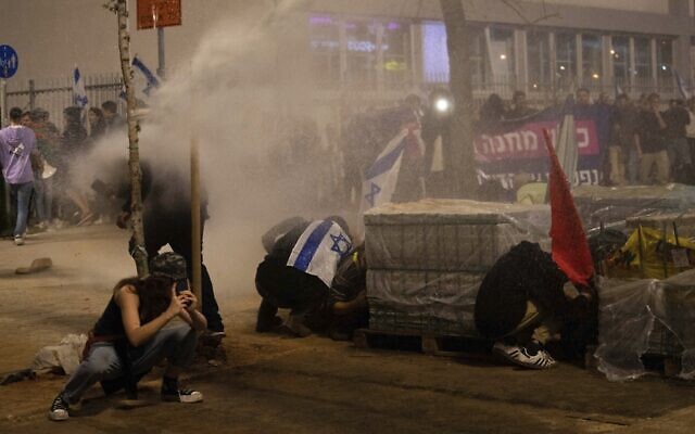 La police utilise des canons à eau pour disperser les manifestants bloquant une route pendant un rassemblement contre la réforme judiciaire du gouvernement du Premier ministre Benjamin Netanyahu, le 27 mars 2023. (Crédit : AP Photo/Oded Balilty)