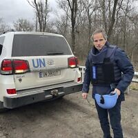 Le chef de l'Agence internationale pour l'énergie atomique, Rafael Mariano Grossi, se tenant sur une route à côté d'un véhicule de l'ONU alors qu'il se rend à la centrale nucléaire de Zaporijjia, dans le sud-est de l'Ukraine, le 29 mars 2023. (Crédit : Bureau de presse de l'AIEA via AP)