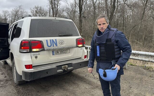 Le chef de l'Agence internationale pour l'énergie atomique, Rafael Mariano Grossi, se tenant sur une route à côté d'un véhicule de l'ONU alors qu'il se rend à la centrale nucléaire de Zaporijjia, dans le sud-est de l'Ukraine, le 29 mars 2023. (Crédit : Bureau de presse de l'AIEA via AP)