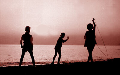 Des enfants sous un coucher de soleil. (Crédit : Vitold Muratov, via Wikimedia Commons)