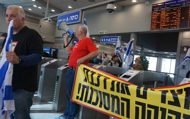  Des manifestants bloquent l'entrée de la gare de Herzliya lors d'une manifestation contre la réforme du système judiciaire du gouvernement, le 1er mars 2023. (Crédit : Emanuel Fabian/Times of Israel)