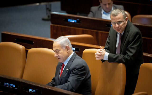 Le Premier ministre Benjamin Netanyahu, à droite, et le ministre de la Justice Yariv Levin lors d'une discussion et d'un vote à la plénière de la Knesset, le 22 février 2023. (Crédit : Yonatan Sindel/Flash90)