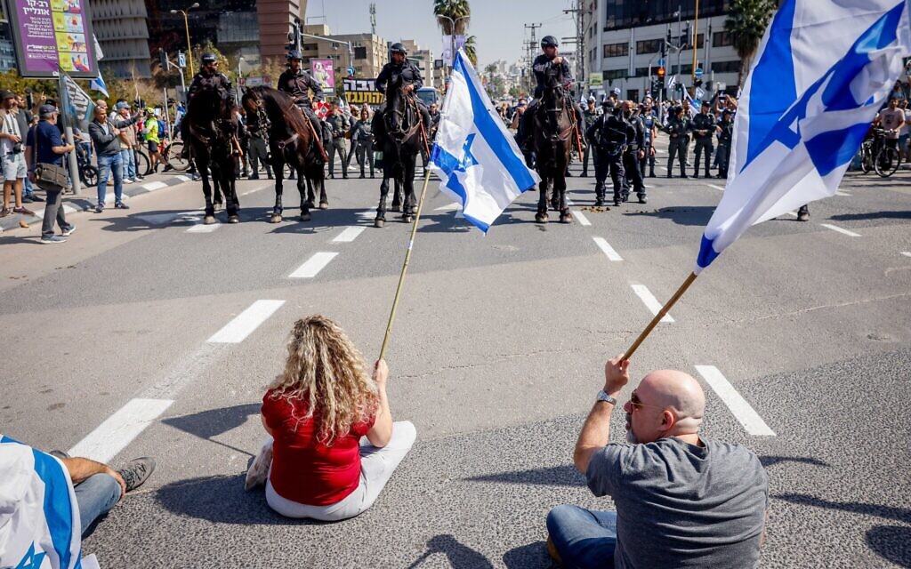 Des manifestants bloquent une route face à des policiers à cheval en signe de protestation contre le projet de réforme judiciaire, à Tel Aviv, le 1er mars 2023. (Crédit : Erik Marmor/Flash90)