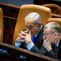 Le Premier ministre Benjamin Netanyahu, à gauche, et le ministre de la Justice Yariv Levin lors d'une discussion et d'un vote à la Knesset, à Jérusalem, le 6 mars 2023. (Crédit : Yonatan Sindel/Flash90)
