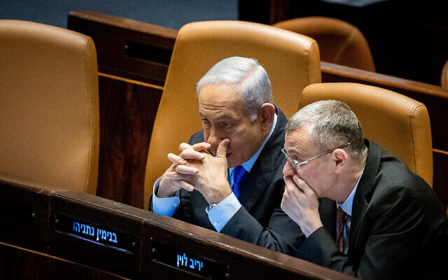 Le Premier ministre Benjamin Netanyahu, à gauche, et le ministre de la Justice Yariv Levin lors d'une discussion et d'un vote à la Knesset, à Jérusalem, le 6 mars 2023. (Crédit : Yonatan Sindel/Flash90)