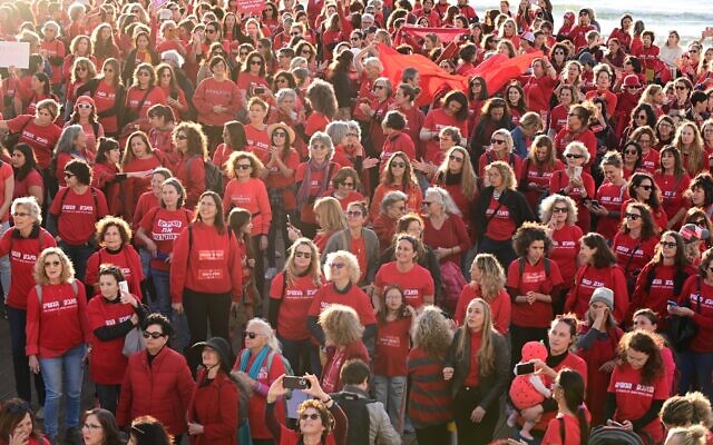 Des centaines de femmes vêtues de rouge marquent la Journée internationale de la femme et manifestent contre la refonte judiciaire prévue par le gouvernement israélien, sur la plage de Tel Aviv, le 8 mars 2023. (Crédit : Tomer Neuberg/Flash90)