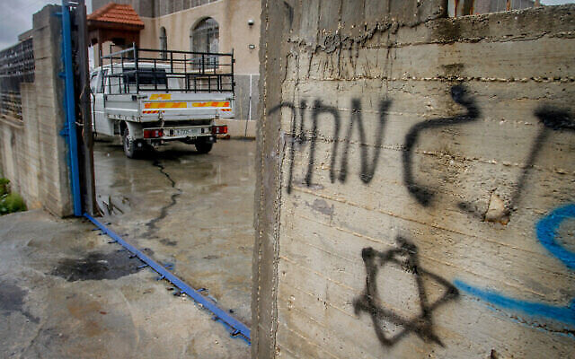 Des voitures appartenant à des Palestiniens et le mur d’une maison ont été graffés, dans le cadre d'un possible crime haineux commis par des résidents d'implantations dans la ville de Salfit, en Cisjordanie, le 20 mars 2023. (Crédit : Nasser Ishtayeh/Flash90)