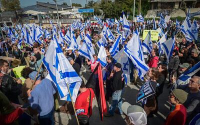 Des manifestants contre la réforme judiciaire prévue par le gouvernement réunis à l'extérieur d'une conférence de l'Autorité foncière israélienne, à Tel Aviv, le 22 mars 2023. (Crédit : Avshalom Sassoni/Flash90)