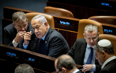 Le Premier ministre Benjamin Netanyahu, au centre, s'entretenant avec le ministre de l'Éducation, Yoav Kisch, à la Knesset, le 22 mars 2023. (Crédit :  Yonatan Sindel/Flash90)