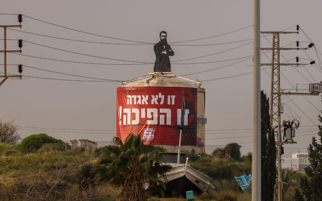 Une grande affiche, où l'on lit "ce n'est pas un rêve, c'est un coup d'État", placée sur une statue de Theodor Herzl dans le cadre d'une manifestation contre la refonte judiciaire, à Herzliya, le 23 mars 2023. Herzl est connu pour avoir dit « Si vous le voulez, ce n'est pas un rêve. » en référence à la création de l'État d'Israël. (Crédit : Yossi Aloni/Flash90)