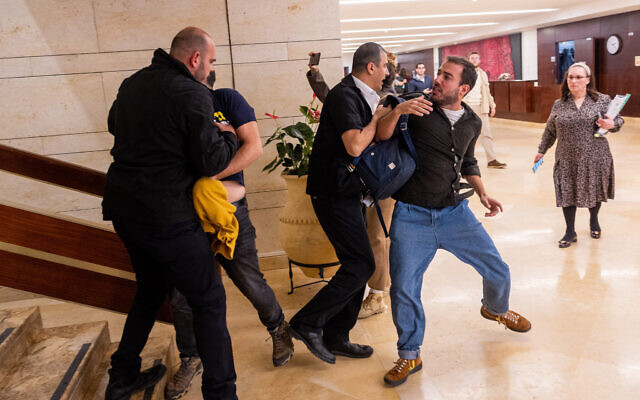 Des manifestants qui s'opposent à la réforme judiciaire prévue par le gouvernement crient au ministre de l'Éducation Yoav Kisch à la Knesset à Jérusalem, le 27 mars 2023. (Crédit : Yonatan Sindel/Flash90)