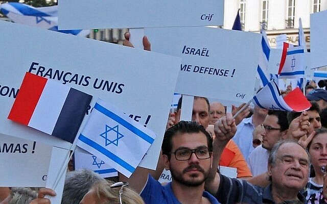 Des manifestants brandissent des drapeaux et des pancartes israéliens et français sur lesquels on peut lire 'Français  unis contre le terrorisme' lors d’un rassemblement devant l’ambassade d’Israël à Paris, France, le 31 juillet 2014. (Crédit : AP Photo/François Mori )