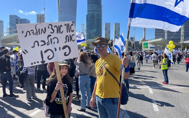Goni, 13 ans, et son père, Eran, lors d'une manifestation contre la réforme judiciaire à Tel Aviv le 9 mars 2023. (Crédit : Carrie Keller Lynn/Times of Israel)
