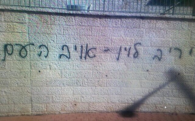 Un graffiti qualifiant le ministre de la Justice Yariv Levin "d'ennemi du peuple" peint à la bombe sur un mur près de sa maison dans la ville centrale de Modiin, le 17 mars 2023. (Crédit : Police israélienne)