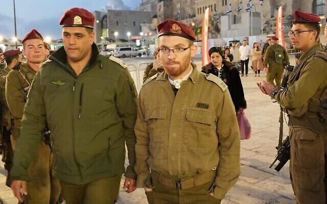 Le Lt. Nadav Weinberg (au centre), blessé dans une fusillade en janvier dernier à Jérusalem, au mur Occidental pour une cérémonie militaire, le 8 mars 2023. (Autorisation : Autorité du mur Occidental)