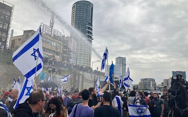 Des canons à eau contre les manifestants pro-démocratie bloquant l'autoroute Ayalon, à Tel Aviv, le 23 mars 2023. (Crédit : JH/Times of Israel)