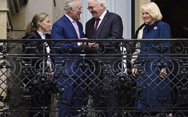 Le roi Charles III, à gauche, rit avec le président allemand Frank-Walter Steinmeier, au centre, alors que la reine consort Camilla, Camilla, se tient à droite sur le balcon de la mairie de Hambourg, dans le nord de l'Allemagne, le 31 mars 2023. (Crédit :   John MACDOUGALL / AFP)