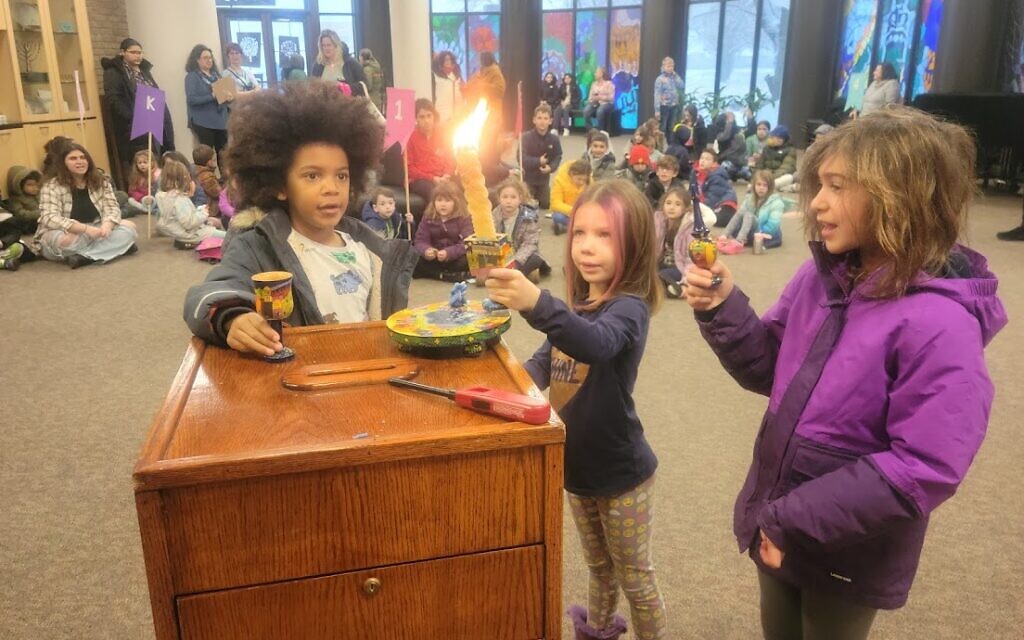 Des enfants allument des bougies au Talmud Torah "Yachad" à Oak Park, dans le Michigan. (Crédit : Yachad via JTA)