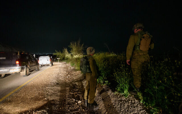 Des soldats israéliens recherchant des roquettes tirées depuis la Syrie sur le plateau du Golan aux premières heures du 9 avril 2023. (Crédit : Ayal Margolin/Flash90)