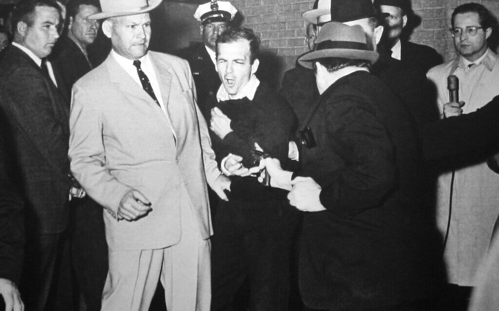 Jack Ruby tirant sur Lee Harvey Oswald, escorté par l'inspecteur de police de Dallas Jim Leavelle (à gauche), 24 novembre 1963 (Crédit : Robert H. Jackson / Wikipedia)