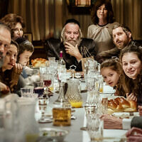 Dudu Fisher (au centre) dirige le dîner de Shabbat dans une scène de la série Netflix 'Rough Diamonds'. (Crédit : Netflix)
