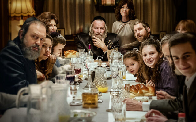 Dudu Fisher (au centre) dirige le dîner de Shabbat dans une scène de la série Netflix 'Rough Diamonds'. (Crédit : Netflix)