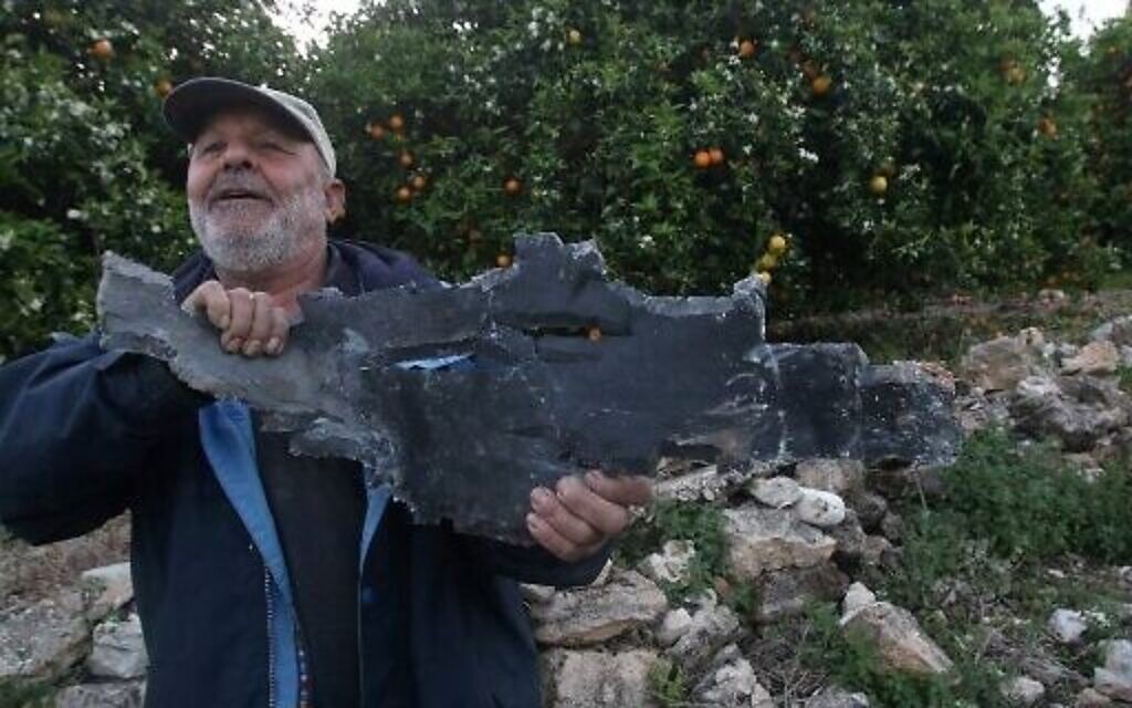 Un homme tient des éclats de roquettes après des frappes aériennes israéliennes à Al Qulaylah, dans le sud du Liban, le 7 avril 2023. (Crédit : Mahmoud Zayyat/AFP)