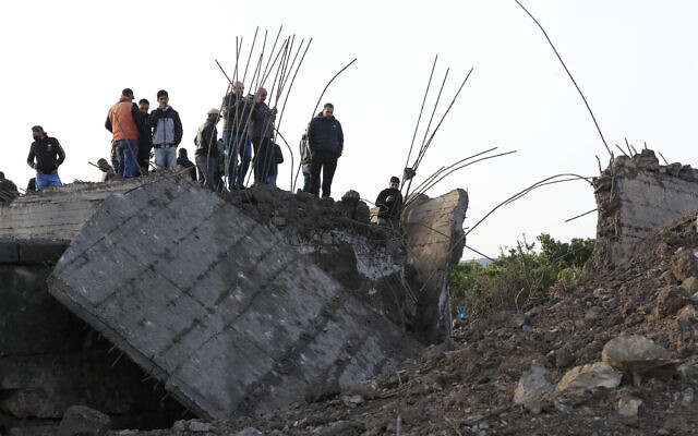 Des habitants vérifient un petit pont qui a été détruit par une frappe aérienne israélienne, dans le village de Maaliya, au sud du Liban, le 7 avril 2023. (Crédit : Mohammed Zaatari/AP)