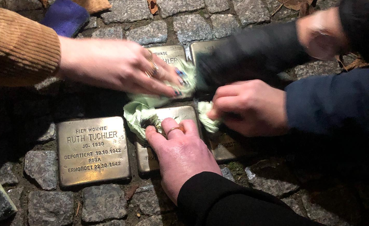 Des bénévoles allemands et de l'organisation de  'Zikaron BaSalon' nettoient des pavés de la mémoire en commémoration de la nuit de Cristal, le 11 novembre 2022. (Autorisation : MakeTheirMemoryShine)