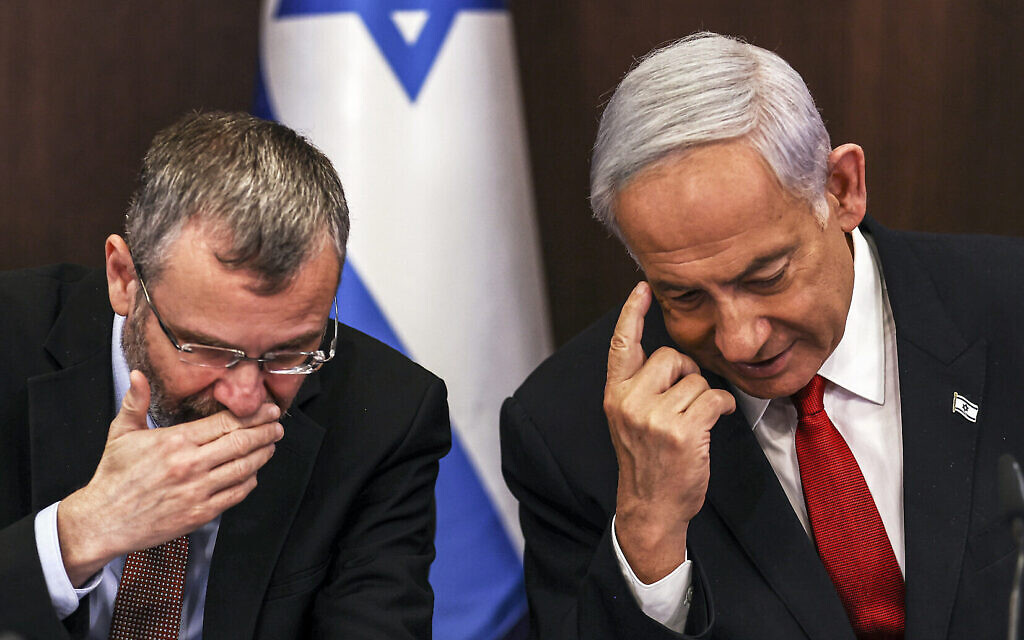 Le Premier ministre israélien Benjamin Netanyahu, à droite, parle avec le ministre de la Justice, Yariv Levin, pendant une rencontre hebdomadaire au bureau du Premier ministre à Jérusalem, le 2 avril 2023. (Crédit :  RONEN ZVULUN/AFP)