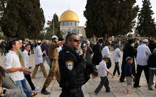 Les forces de sécurité israéliennes escortant les visiteurs juifs sur le mont du Temple, pendant le ramadan, qui coïncide cette année avec la fête de Pessah, à Jérusalem, le 9 avril 2023. (Crédit : Ahmad Gharabli/AFP)