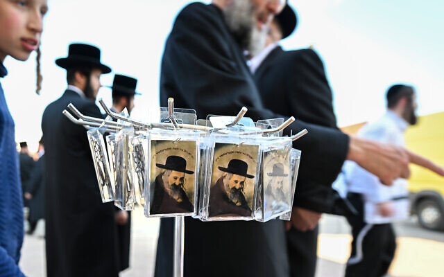 Des cartes souvenirs à l'effigie du rabbin Yeshaya Steiner, également connu sous le nom de Rebbe Shayale, sont exposées à la vente devant son ancienne maison dans le village de Bodrogkeresztur, en Hongrie, le 23 avril 2023, lors d'un pèlerinage de juifs hassidiques à l'occasion du 98e anniversaire de la mort du rabbin Steiner.(Crédit :ATTILA KISBENEDEK / AFP)