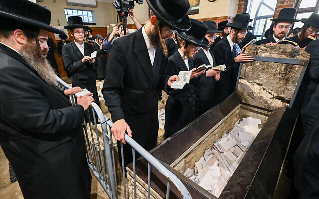 Des Juifs hassidiques prient devant la tombe de feu le rabbin miracle Yeshaya Steiner, également connu sous le nom de Rebbe Shayale, dans le village de Bodrogkeresztur, en Hongrie, le 23 avril 2023, lors d'un pèlerinage de juifs hassidiques à l'occasion du 98e anniversaire de la mort du rabbin Steiner. (Crédit : ATTILA KISBENEDEK / AFP)