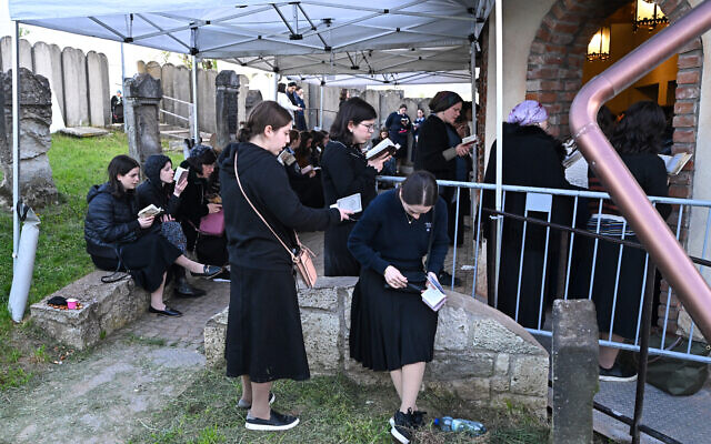 Des Juifs hassidiques prient près de la tombe de feu le rabbin miracle Yeshaya Steiner, également connu sous le nom de Rebbe Shayale, dans le village de Bodrogkeresztur, en Hongrie, le 23 avril 2023, lors d'un pèlerinage de juifs hassidiques à l'occasion du 98e anniversaire de la mort du rabbin Steiner. (Crédit : ATTILA KISBENEDEK / AFP)