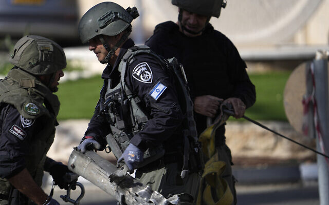 La police israélienne retire les restes d'une roquette tirée depuis le Liban à Shlomi, dans le nord d'Israël, le 6 avril 2023. (Crédit : AP Photo/Ariel Schalit)