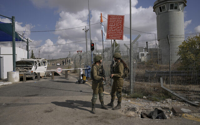 Des soldats israéliens sur le site d'une attaque à la voiture-bélier au checkpoint de Maccabim en Cisjordanie, le 2 novembre 2022. (Crédit :  AP Photo/Mahmoud Illean)