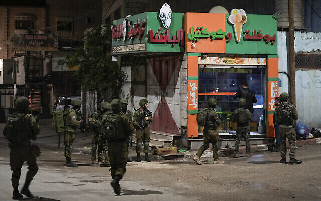 Des soldats israéliens déployés sur les lieux où un Palestinien a ouvert le feu sur des soldats dans la ville de Huwara, en Cisjordanie, le 25 mars 2023. (Crédit : AP Photo/Majdi Mohammed)